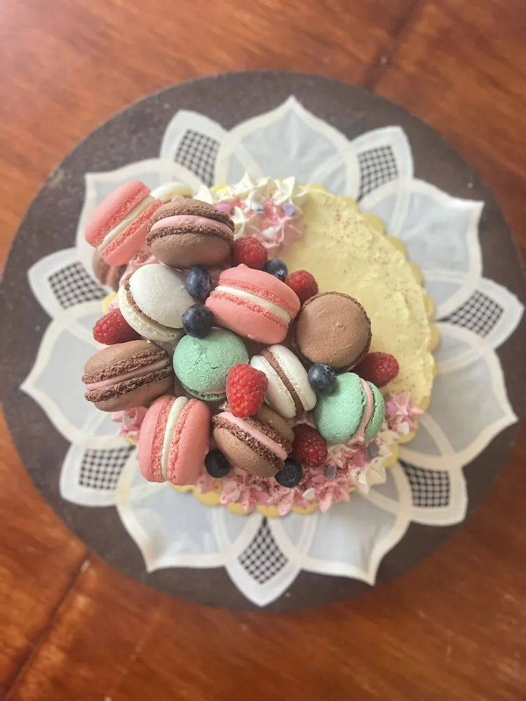 Pastel de cumpleaños decorado con macarons de colores y frutos rojos