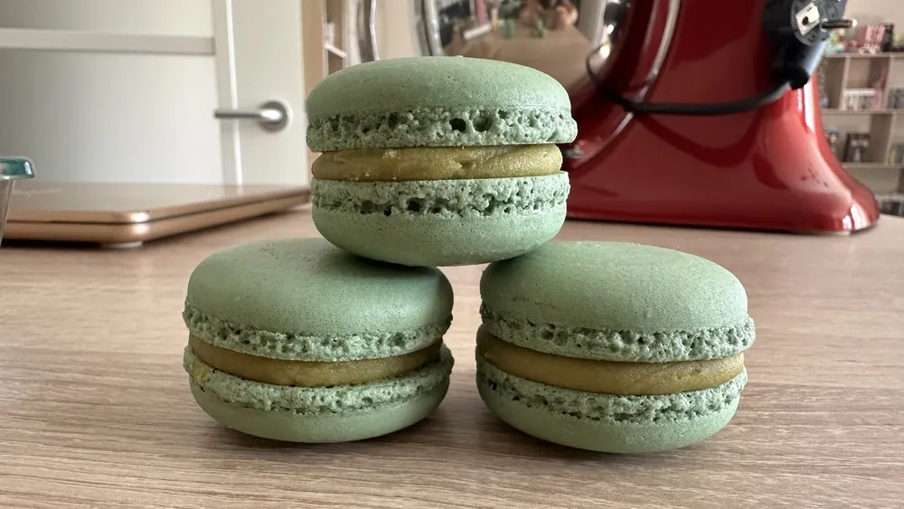 Tres macarons verdes rellenos de ganache de pistacho apilados
