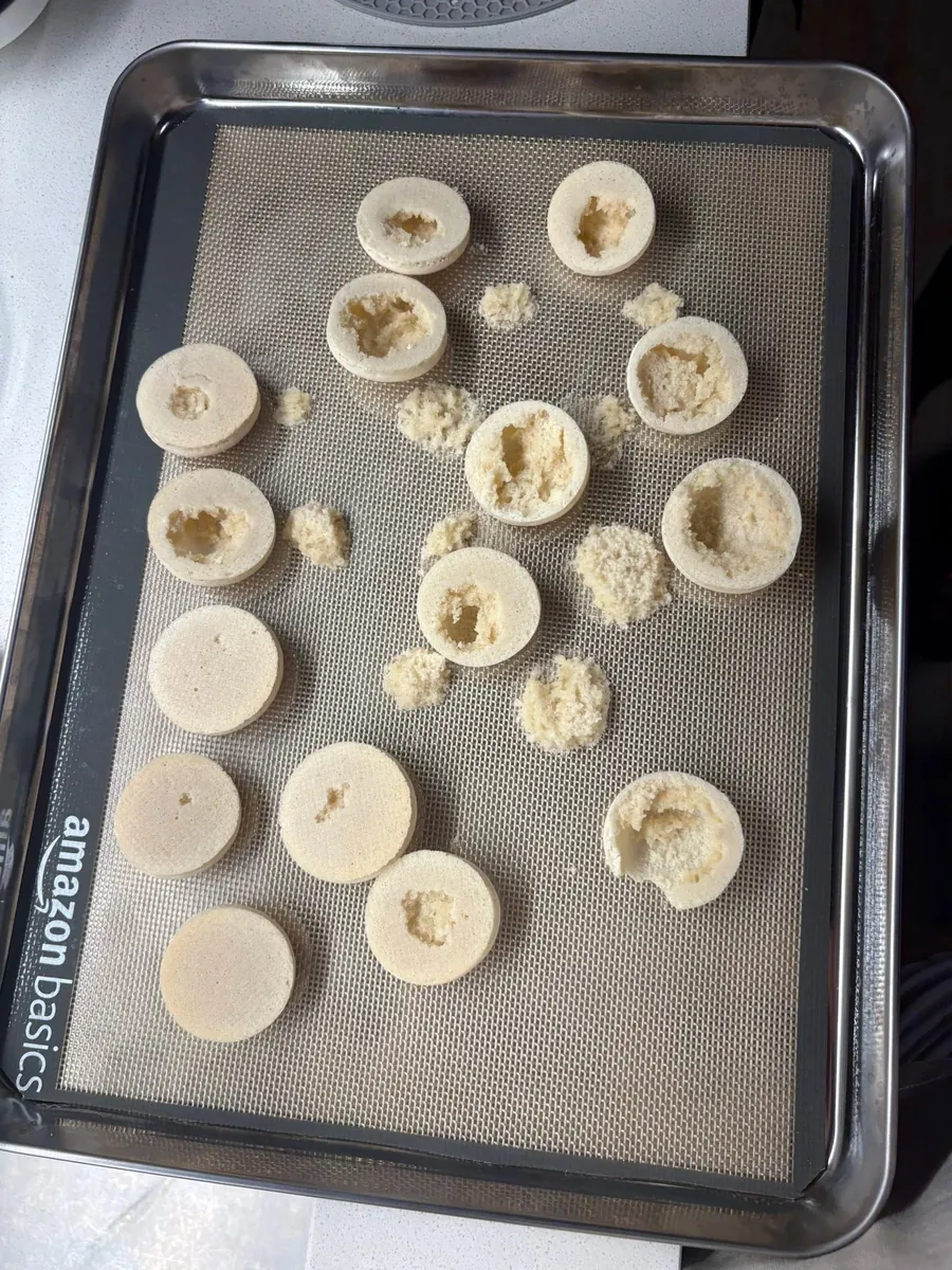 Tapas de macaron horneadas y abiertas que muestran el interior hueco