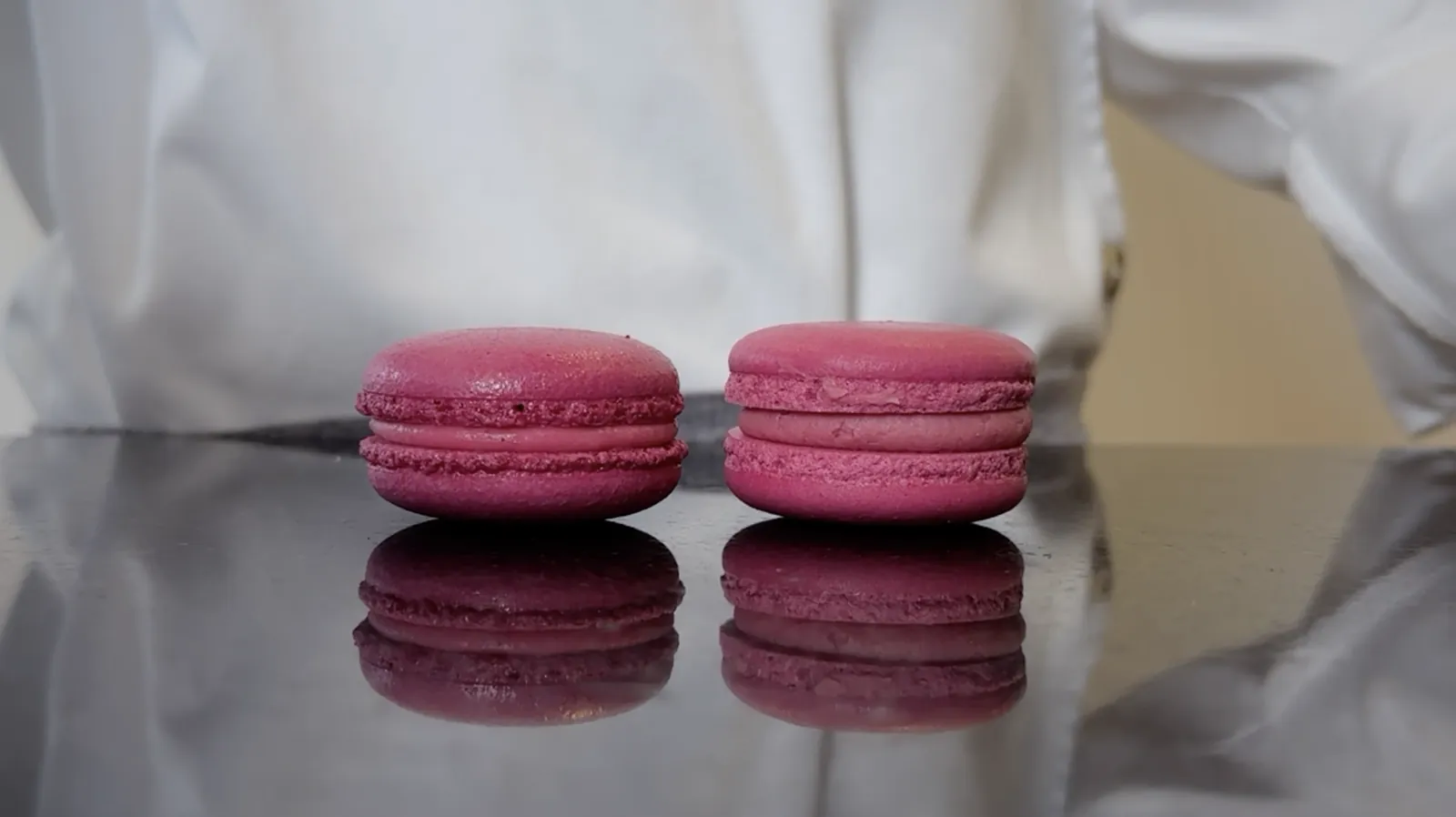 Dos macarons de frambuesa lado a lado con diferencias de color y altura