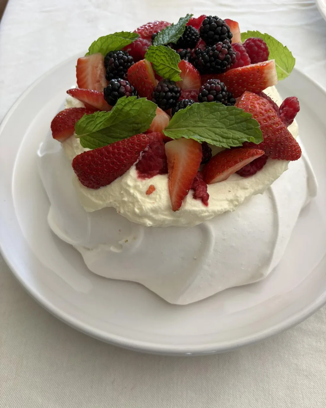 Pavlova blanca con crema y frutos rojos