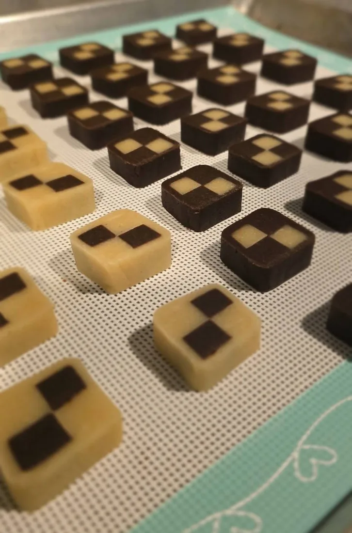 Galletas damero crudas cortadas sobre un tapete de silicona
