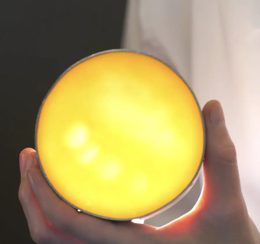 Base de tarta iluminada desde atrás con manchas de luz más intensa donde la masa quedó más delgada