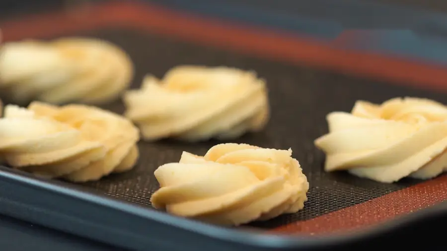 Galletas de mantequilla formadas con manga sobre un tapete