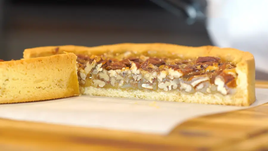 Pecan pie cortado que muestra la base y el relleno de nueces