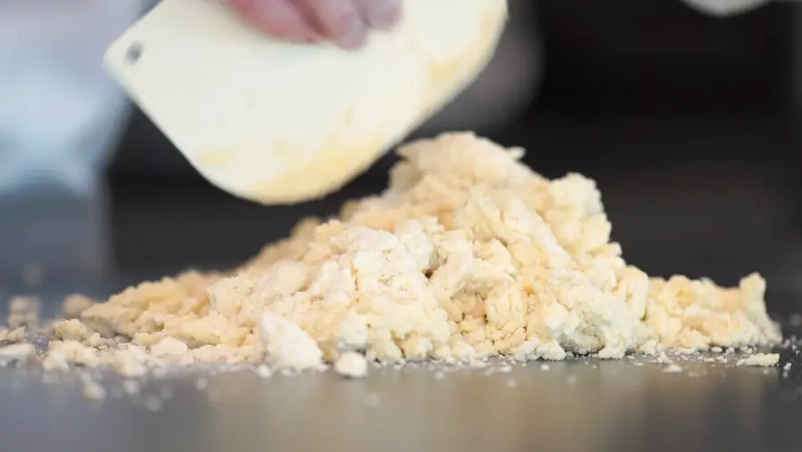 Masa en punto de arena durante el sablage, con una raspa
